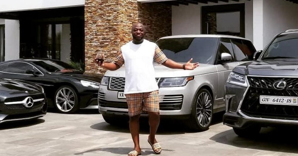 Dr. Kofi Amoa Abban posing with some of his cars in his house.
