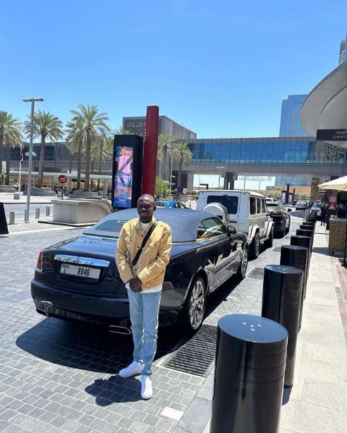 Enokay69 posing by a Rolls Royce during his holiday in Dubai
