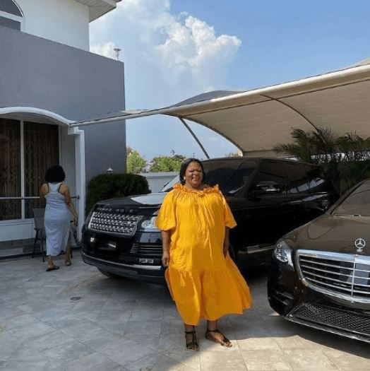 Sarkodie's mom posed by the rapper's cars inside his house in Ghana. 
