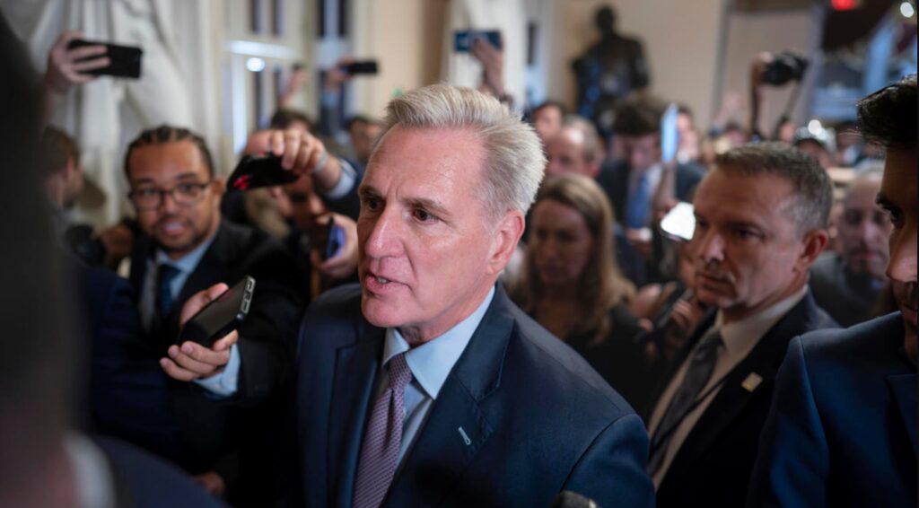Speaker of the House Kevin McCarthy is surrounded by press and police on the way to the House chamber at the Capitol in Washington on Tuesday, Oct. 3, 2023.J. SCOTT APPLEWHITE / AP